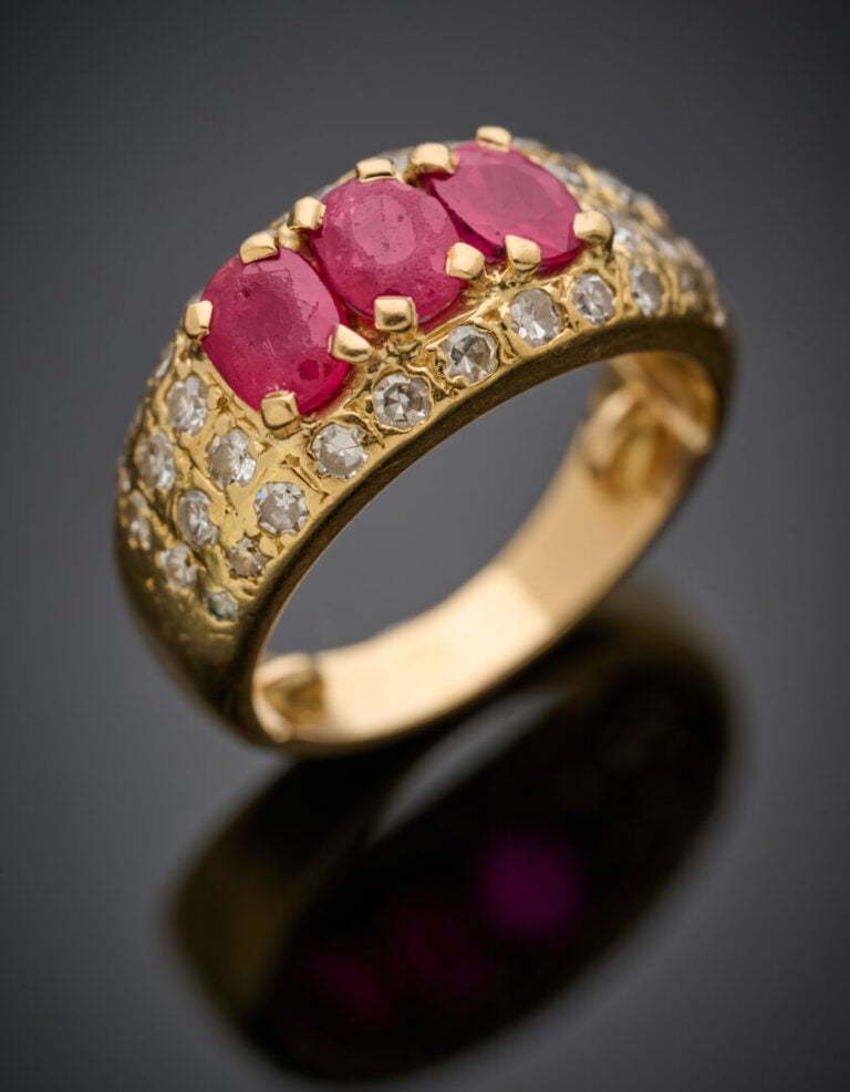 BAGUE "jonc" en or jaune (750‰) serti d'un alignement de trois pierres rouges d…