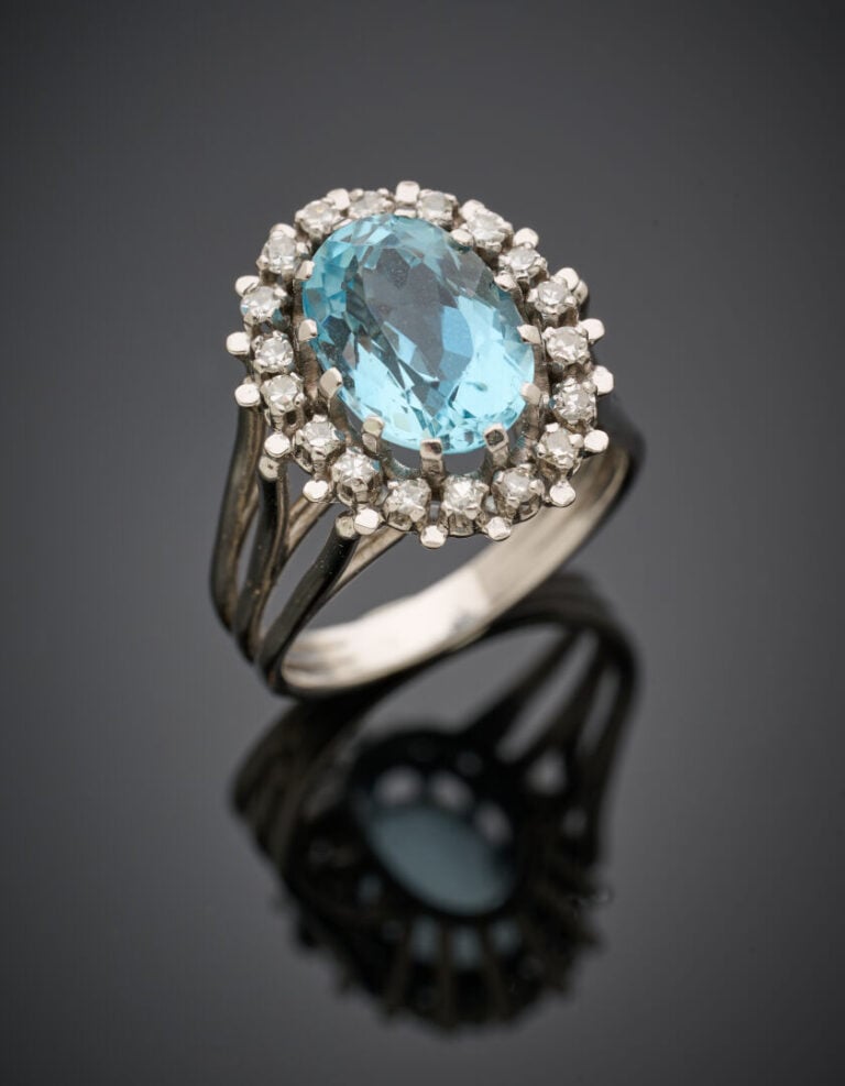 BAGUE "Marguerite" en fils d'or gris (750‰) surmontée d'une aigue-marine de for…