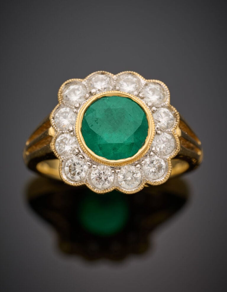 BAGUE "marguerite" en or jaune (750°/°°) serti d'une émeraude ronde, entourée d…