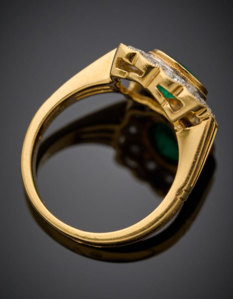 BAGUE "marguerite" en or jaune (750°/°°) serti d'une émeraude ronde, entourée d…