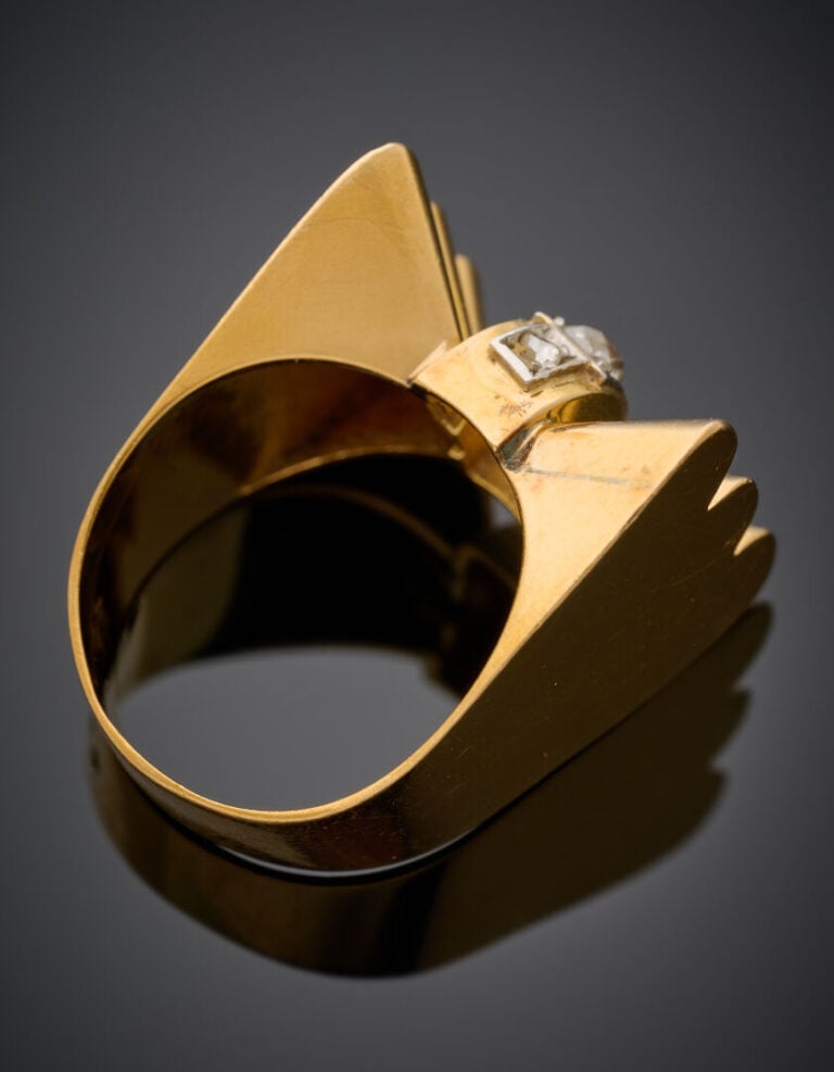 BAGUE "nœud" stylisé en platine (950‰) et or jaune (750‰) godronné, centrée d'u…