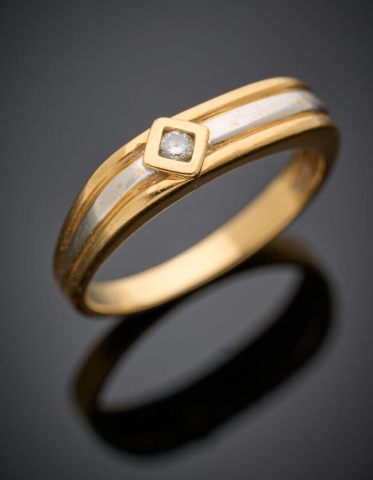 BAGUE plate pour homme deux ors (750°/°°) godronnés, flanquée d'un diamant en s…