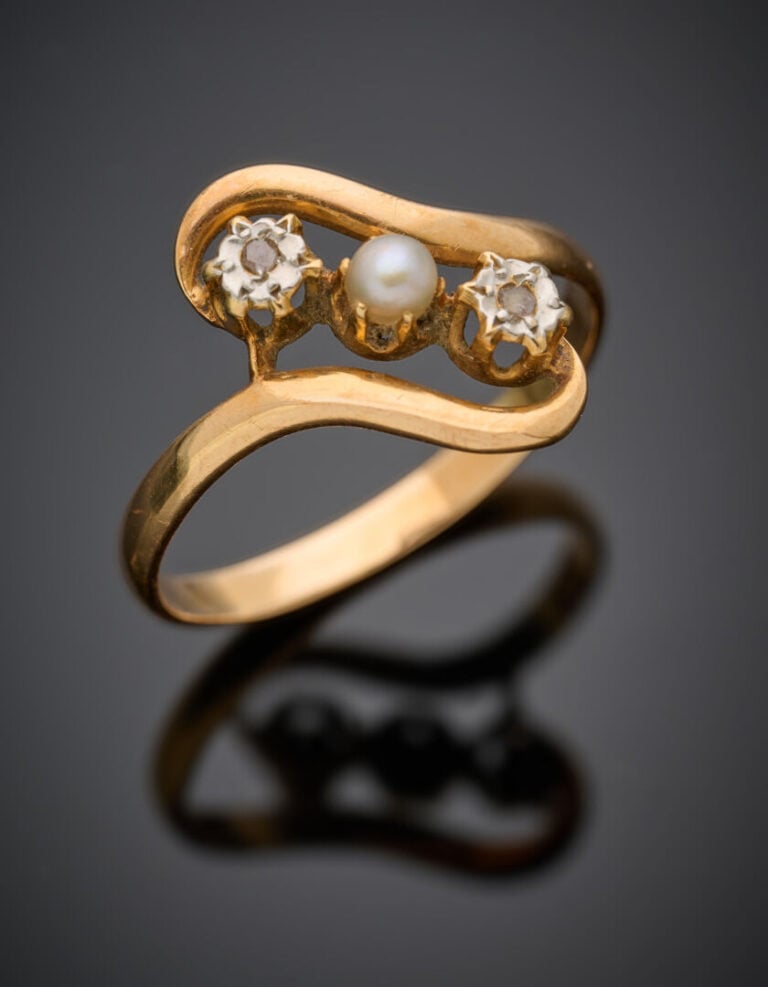 BAGUE sinueuse en or jaune (750°/°°) ajouré, serti de deux petits diamants tail…