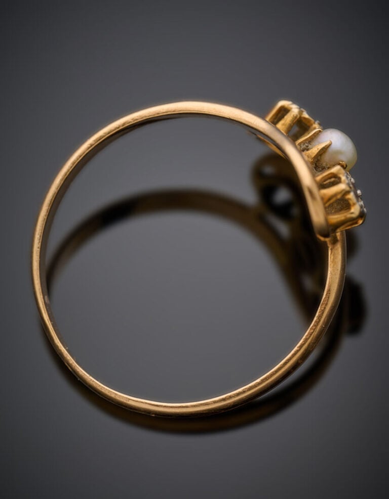 BAGUE sinueuse en or jaune (750°/°°) ajouré, serti de deux petits diamants tail…