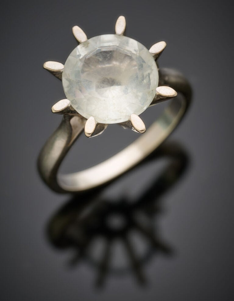 BAGUE solitaire en or gris (750°/°°) ornée d'une pierre incolore de forme ronde…