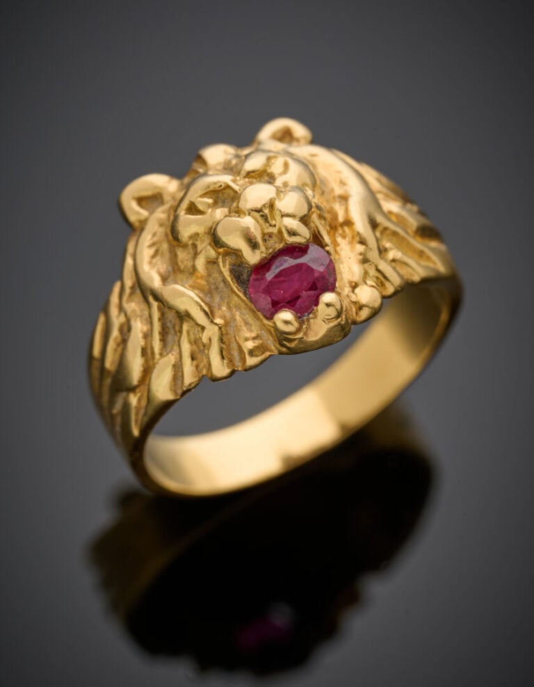 BAGUE "tête de lion" en or jaune (750°/°°) serti d'un rubis de forme ovale. - T…