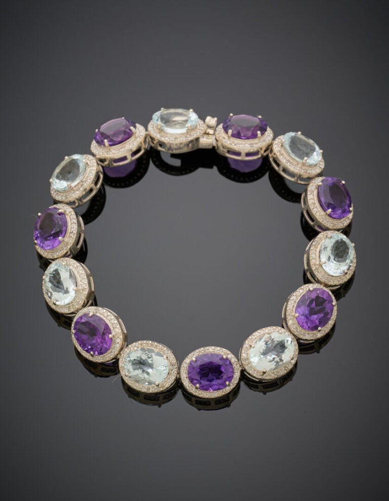 BRACELET en argent (925‰) articulé, serti d'améthystes et aigues-marines ovales…