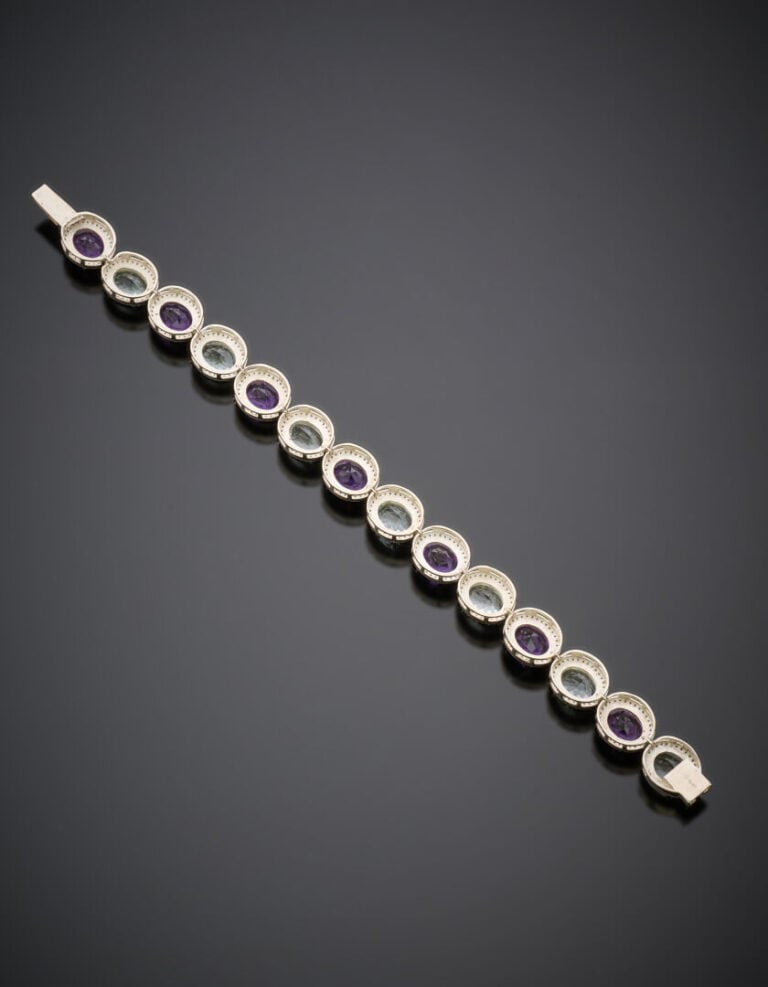 BRACELET en argent (925‰) articulé, serti d'améthystes et aigues-marines ovales…