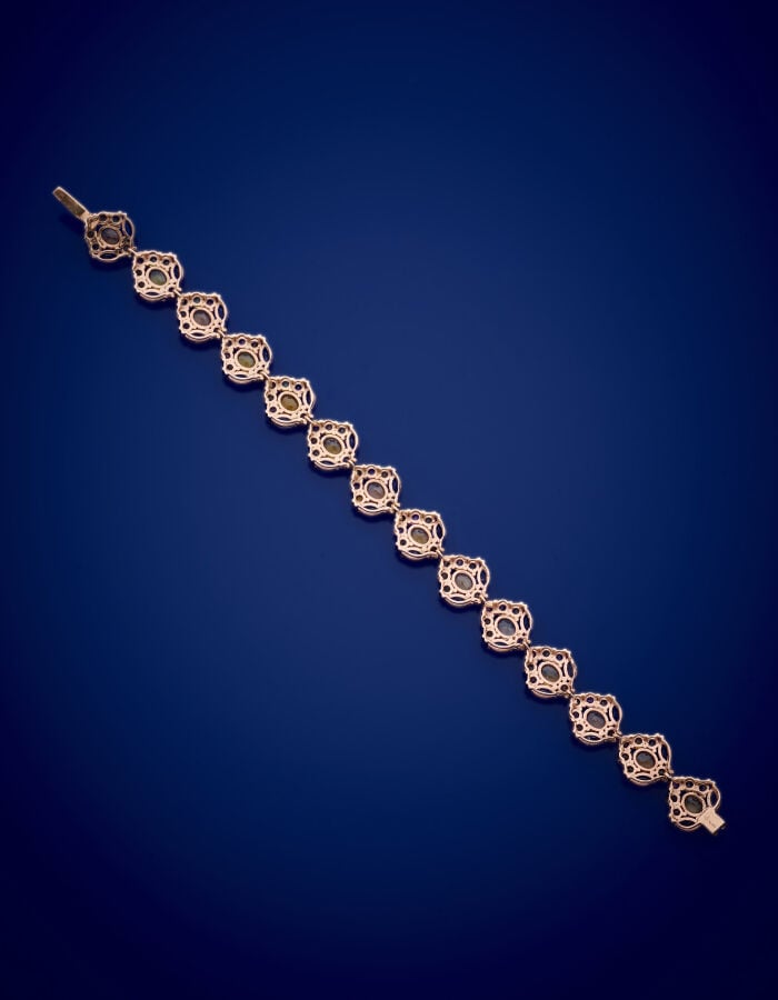 BRACELET en vermeil rose (925‰) composé de quatorze motifs sertis de iolites, s…