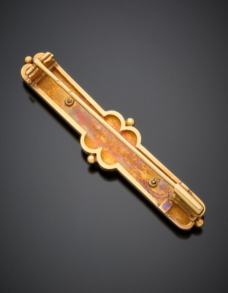 BROCHE "barrette" plate en or jaune (750°/°°) partiellement ciselé, rehaussée d…