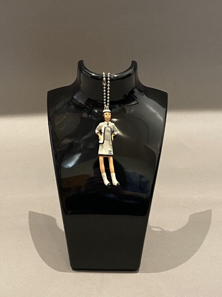 CHANEL circa 1990 - Pendentif figurine "Coco" en résine, siglée au dos, sur deu…