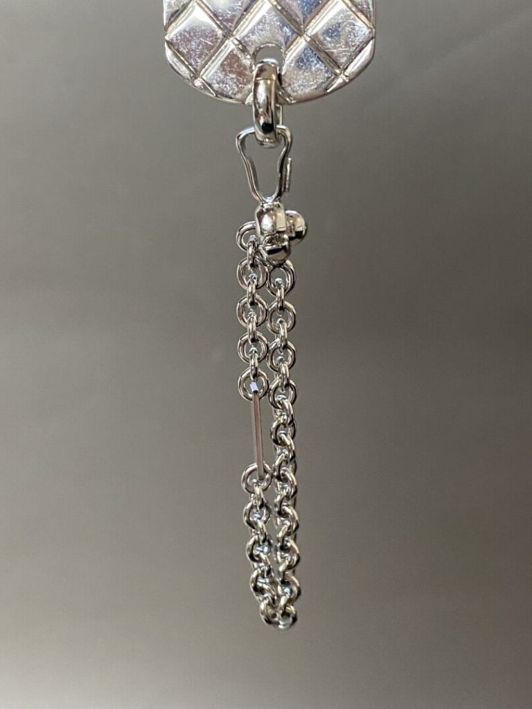 CHANEL circa 2004 - Porte-clefs chaîne en métal argenté retenant un pendentif d…