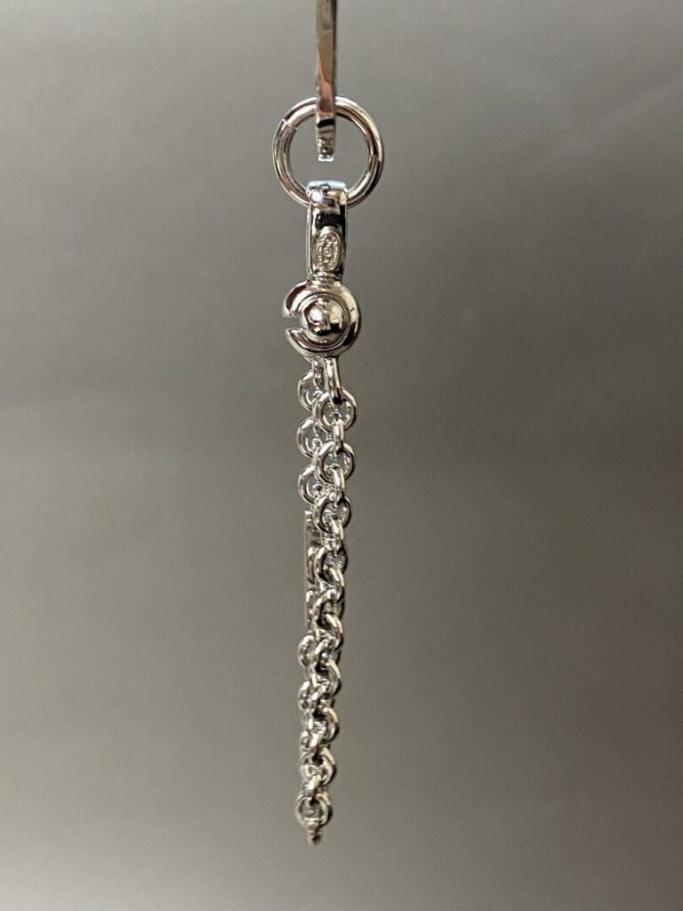 CHANEL circa 2004 - Porte-clefs chaîne en métal argenté retenant un pendentif d…