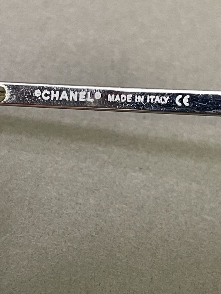 CHANEL - Paire de lunettes en métal, logo Chanel avec strass sur les côtés - Av…