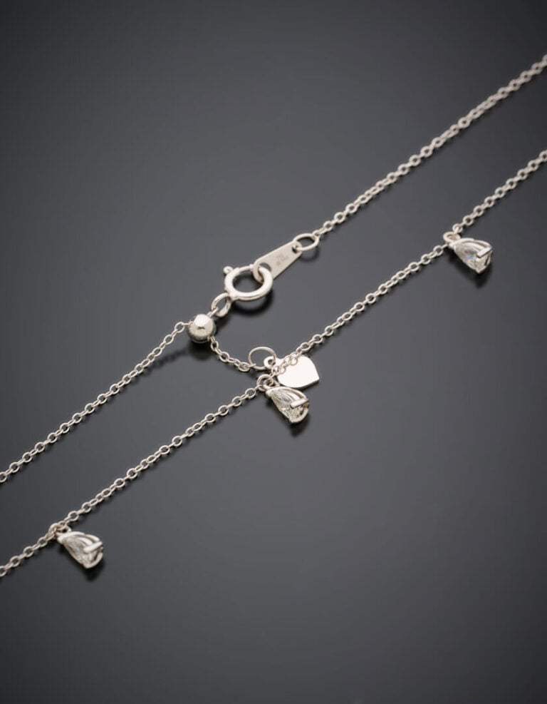 COLLIER chaînette en or gris (750‰) retenant cinq diamants taillés en poire, en…
