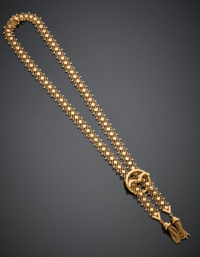 COLLIER composé de deux rubans "résille" en or jaune (750‰) retenant deux pompo…