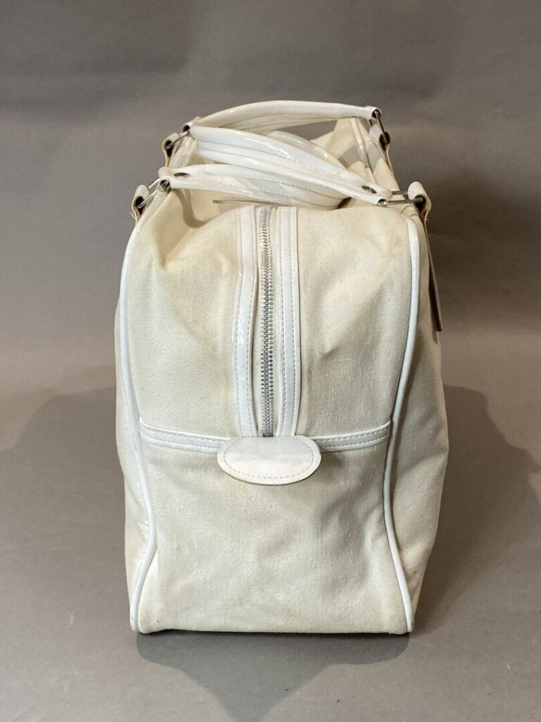 COURREGES - Sac bowling en toile et cuir ivoire, double poignée en cuir verni b…