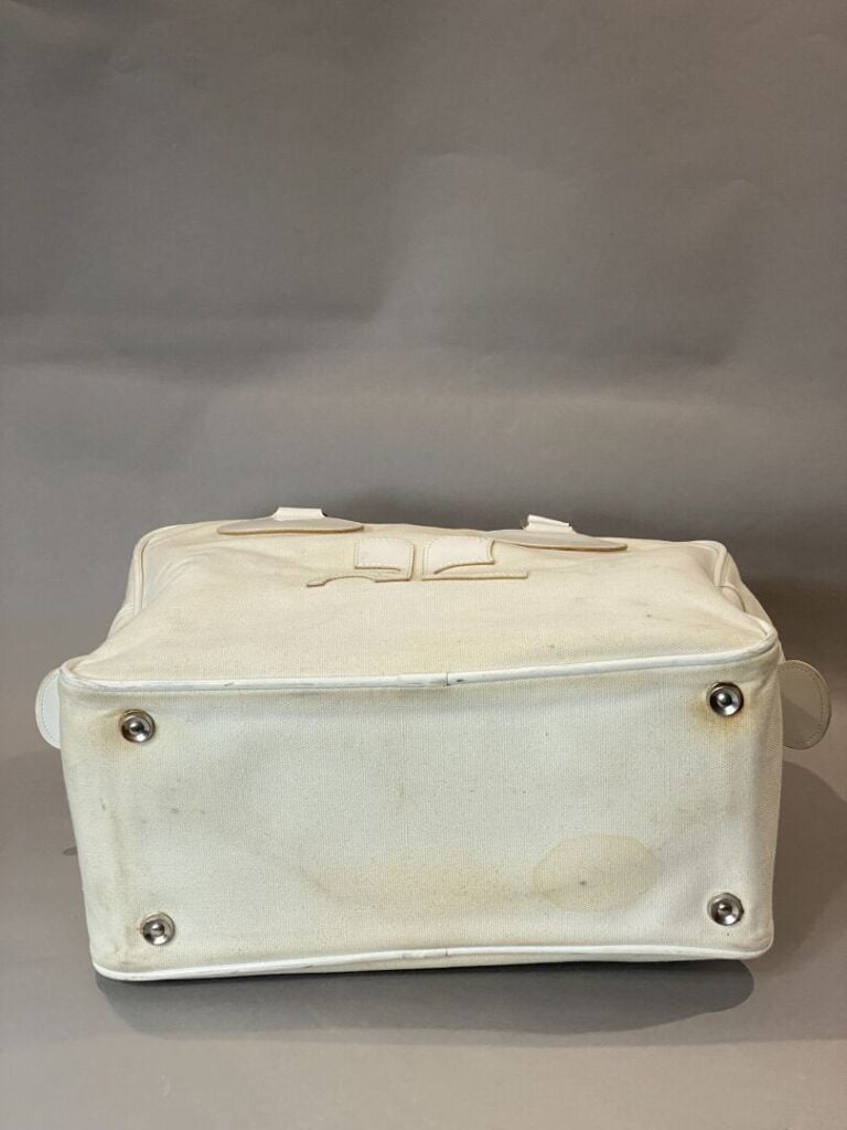 COURREGES - Sac bowling en toile et cuir ivoire, double poignée en cuir verni b…