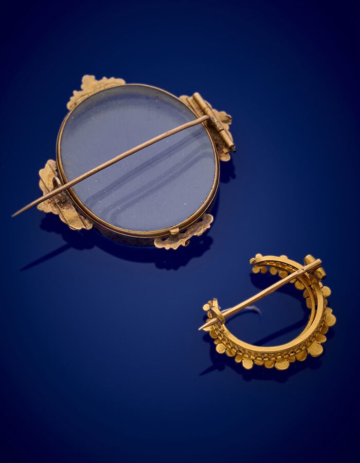 Deux BROCHES en or jaune (750‰) comprenant un porte-photo ovale en verre entour…