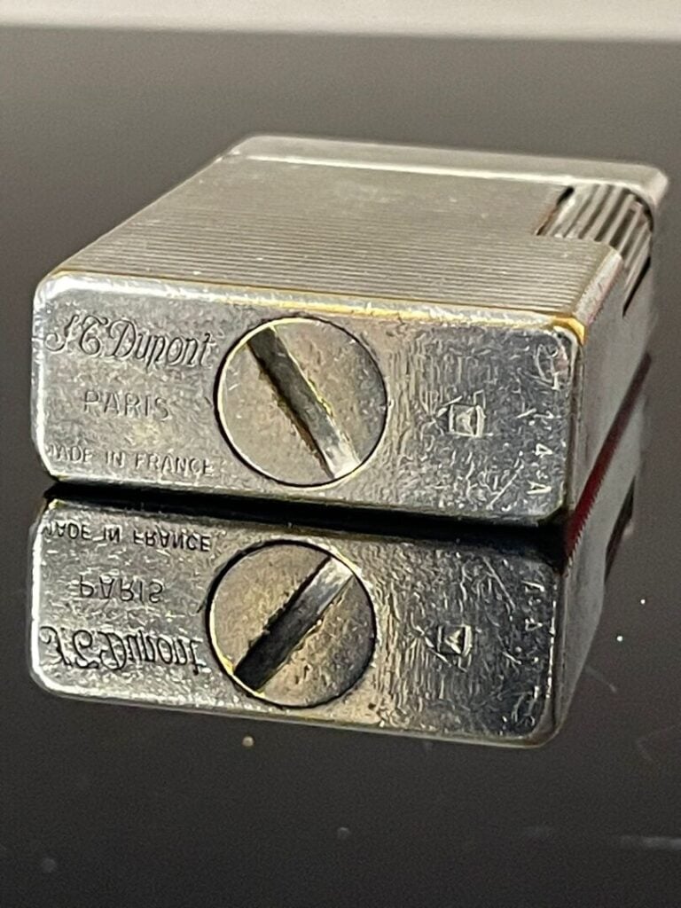DUPONT - Briquet en métal argenté à décor rainuré, chiffré L.R - H : 5.8 cm…
