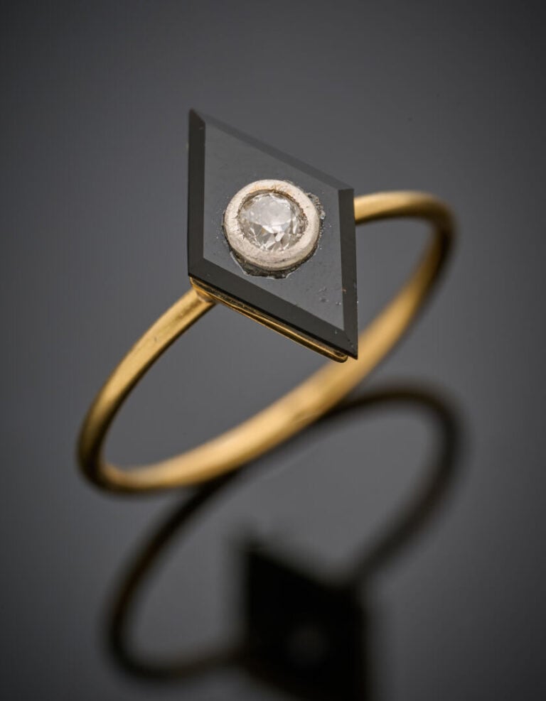 Fine BAGUE en or jaune (750°/°°) surmontée d'un motif losangique en onyx flanqu…