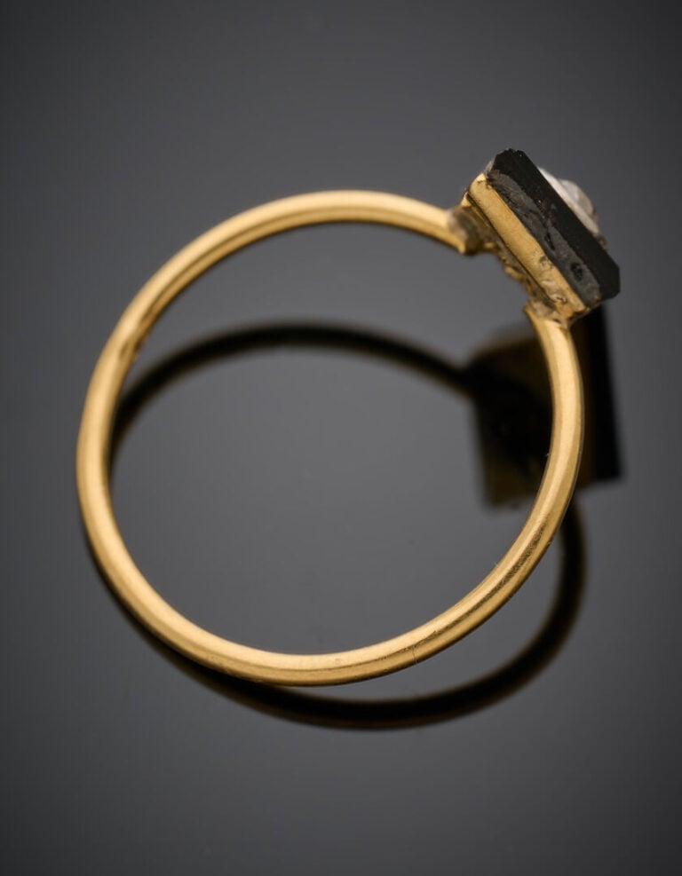 Fine BAGUE en or jaune (750°/°°) surmontée d'un motif losangique en onyx flanqu…