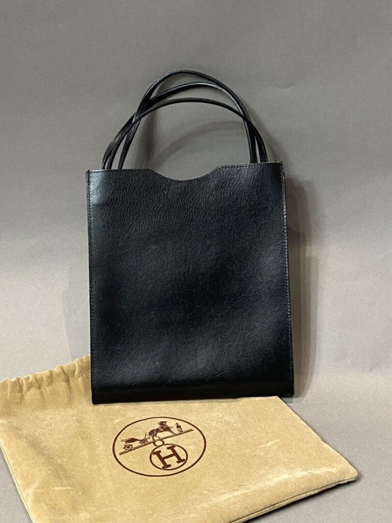 HERMÈS - Sac « ONIMETOU » en cuir box noir, porté épaule ou bandoulière. - H19/…