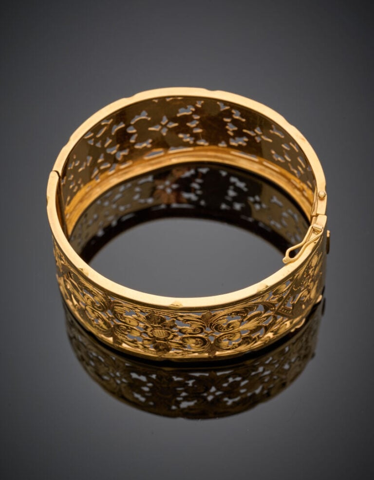 Large BRACELET manchette rigide ouvrant en or jaune (750‰) repercé et ciselé à…