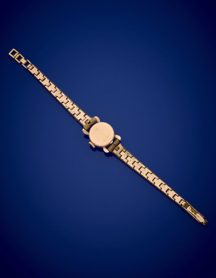 LOT comprenant : - - un BRACELET MONTRE ronde de dame en or jaune (750‰), tache…