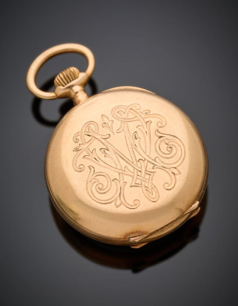 MONTRE de COL en or jaune (750‰) ciselé d'un monogramme. Cadran émail blanc (lé…
