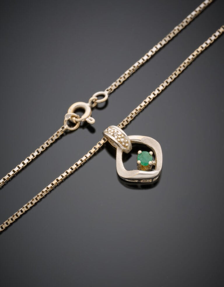 PENDENTIF et sa chaînette en or gris (750‰) ajouré et satiné, serti d'une petit…