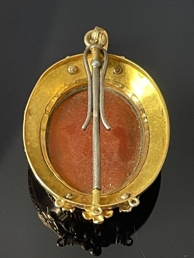 Pendentif médaillon formant broche orné d'un camée ovale sur cornaline, entoura…