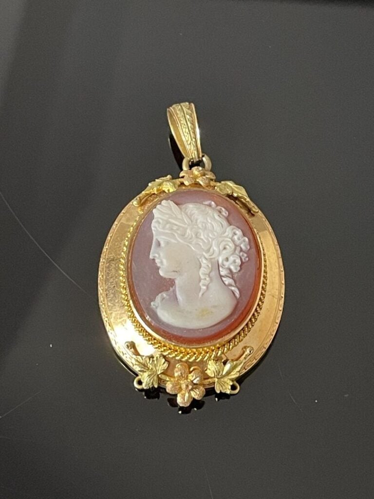 Pendentif médaillon formant broche orné d'un camée ovale sur cornaline, entoura…