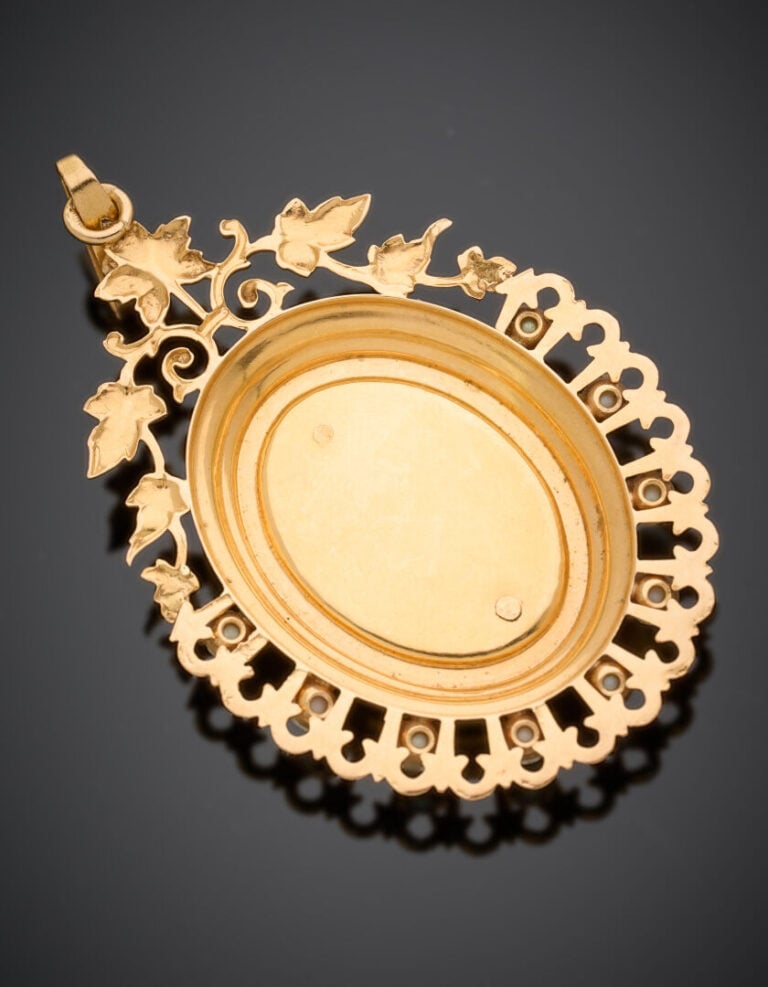PENDENTIF OVALE en or jaune (750°/°°) ajouré et guilloché, centré d'un grenat r…