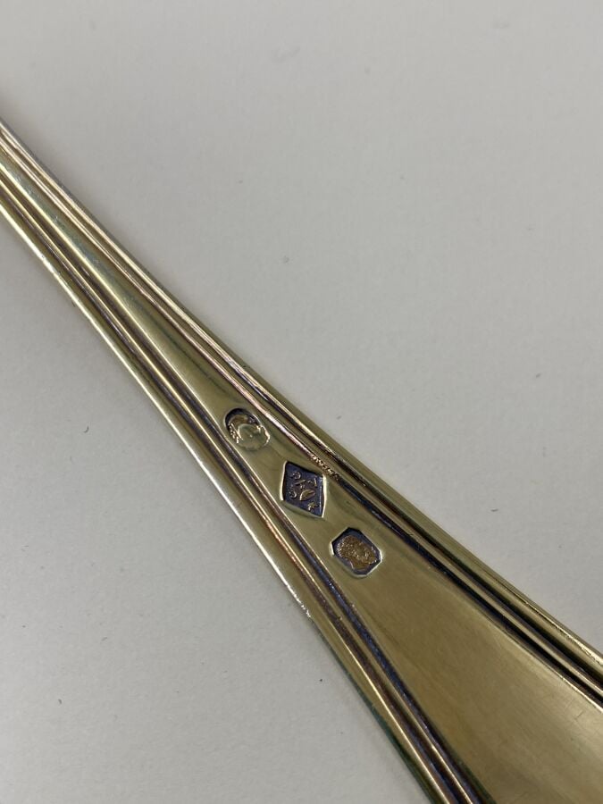 Une cuiller à saupoudrer en vermeil (argent doré 950 0/00), modèle filet contou…
