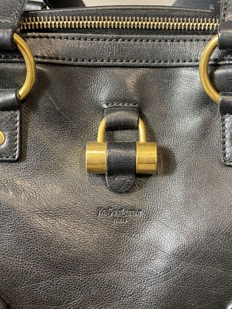 YVES SAINT LAURENT - Sac « Muse » en cuir noir porté main, bijouterie en métal…