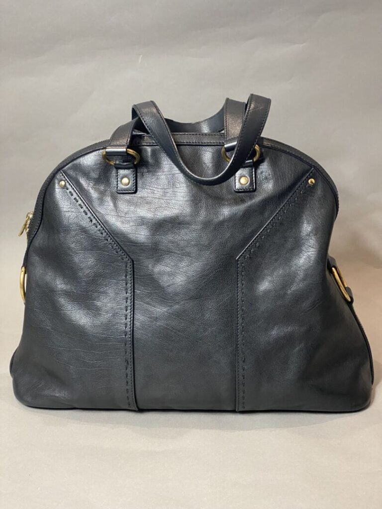 YVES SAINT LAURENT - Sac « Muse » en cuir noir porté main, bijouterie en métal…