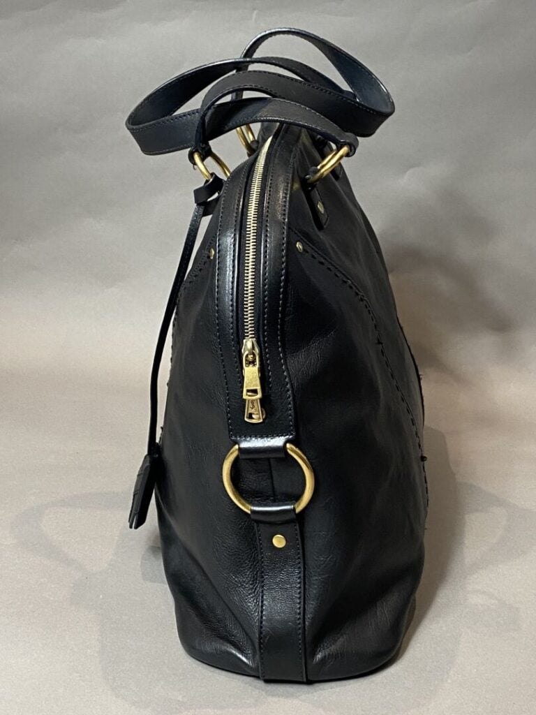 YVES SAINT LAURENT - Sac « Muse » en cuir noir porté main, bijouterie en métal…