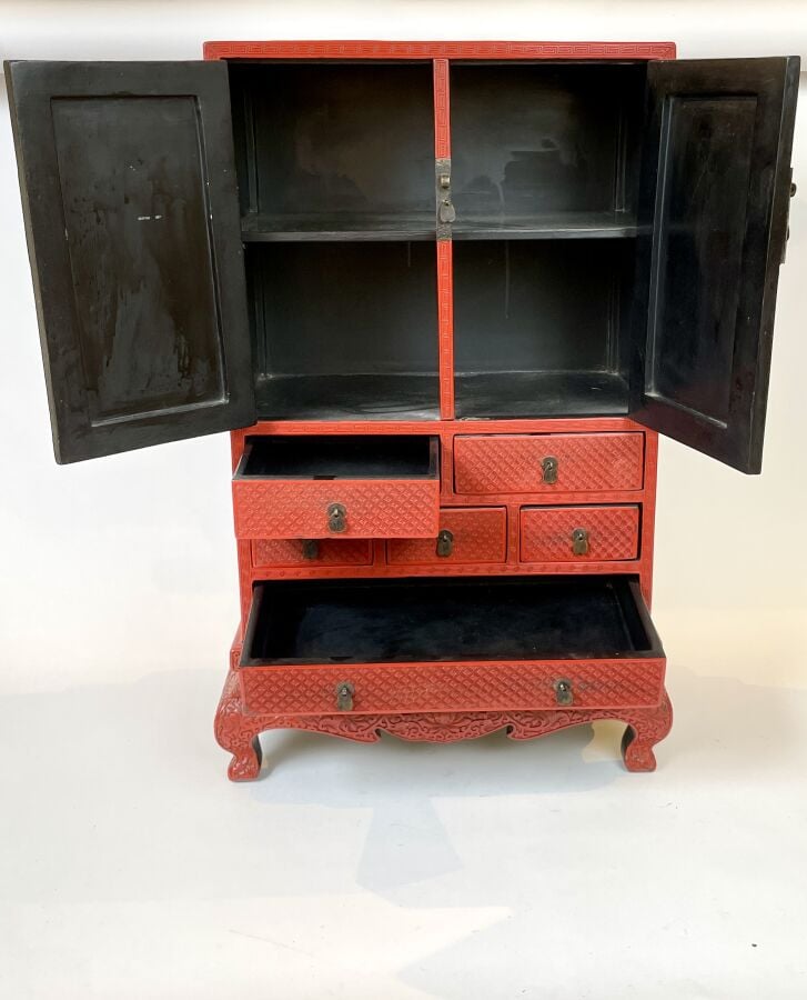 CHINE. XXème Petit cabinet en laque cinabre sculptée de paysages ouvrant par de…
