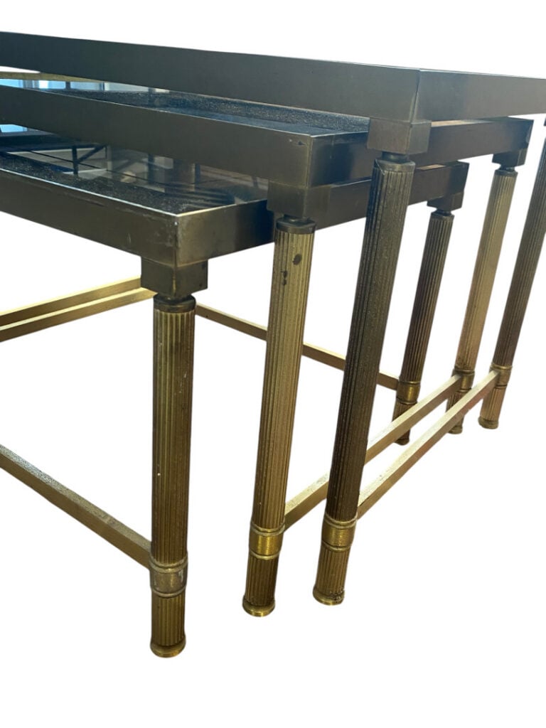Ensemble de trois tables gigognes en métal doré et plateaux de verre fumé, repo…