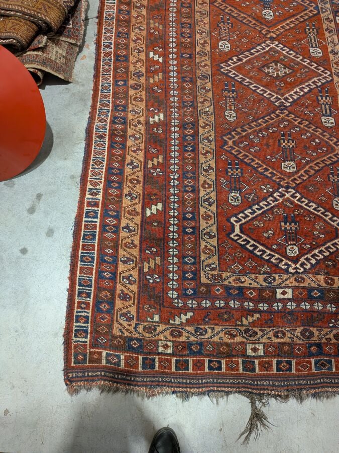 Grand tapis oriental à 6 médaillons losangiques sur fond rouge agrémenté de 13…