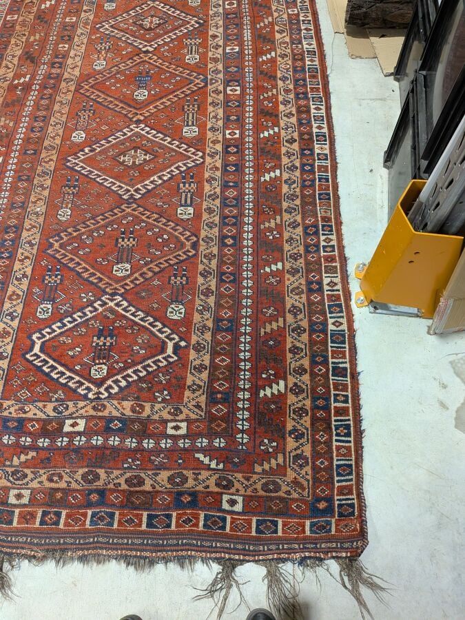 Grand tapis oriental à 6 médaillons losangiques sur fond rouge agrémenté de 13…