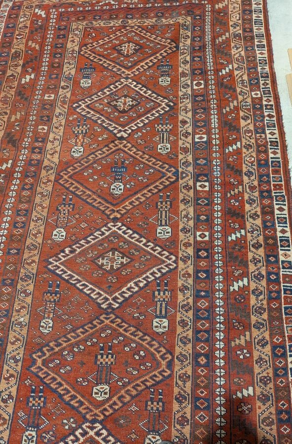 Grand tapis oriental à 6 médaillons losangiques sur fond rouge agrémenté de 13…