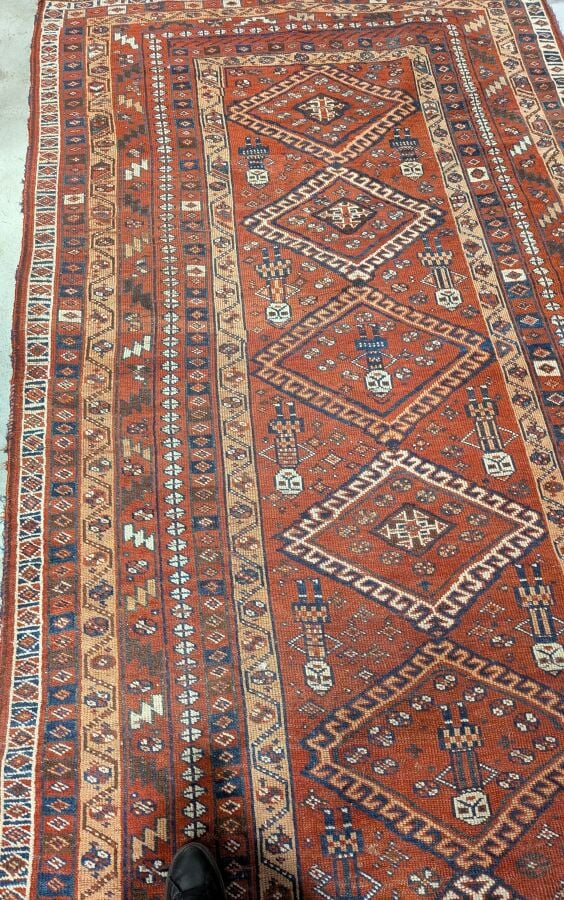 Grand tapis oriental à 6 médaillons losangiques sur fond rouge agrémenté de 13…
