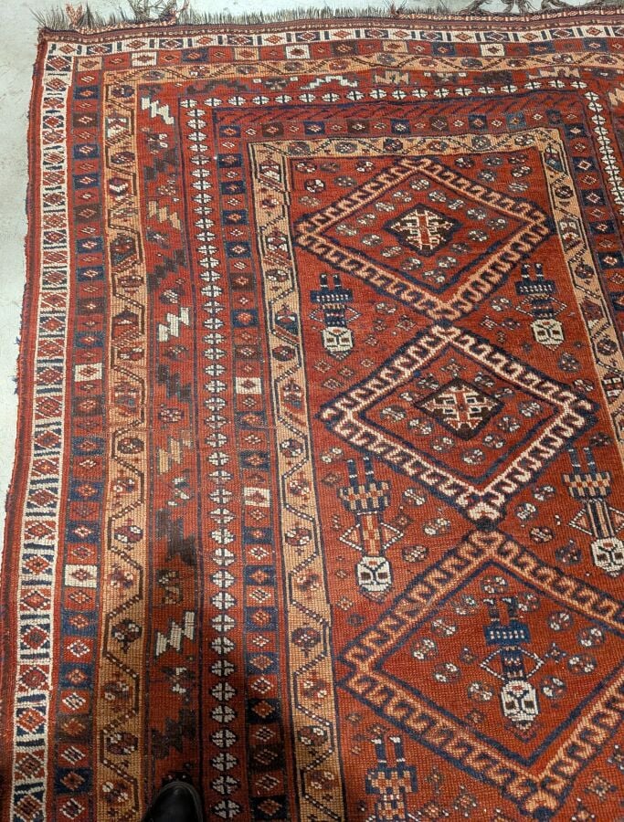 Grand tapis oriental à 6 médaillons losangiques sur fond rouge agrémenté de 13…