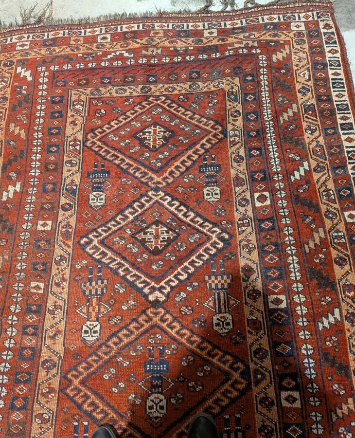 Grand tapis oriental à 6 médaillons losangiques sur fond rouge agrémenté de 13…
