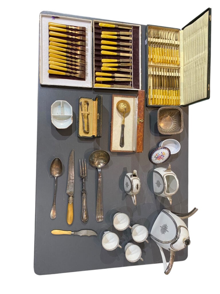 Mannette comprenant divers couverts, cendriers, plateaux, fruit en verre, boîte…