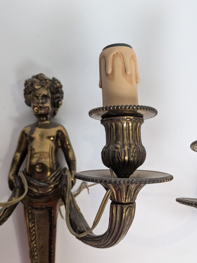Paire d'appliques en bronze doré figurant un Bacchus enfant tenant deux bras de…