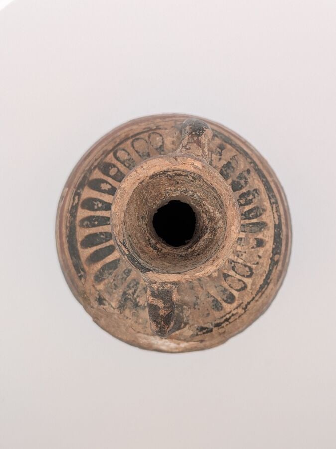 Amphorisque à piédouche tronconique. Il est orné d'une frise de languettes sur…
