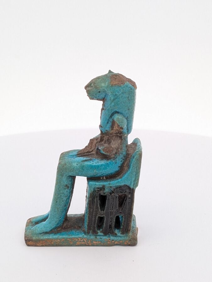 Amulette représentant Sekhmet anthropomorphe assise sur un trône ajouré. - Faïe…